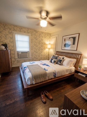 A bedroom with a bed, dresser, and ceiling fan.