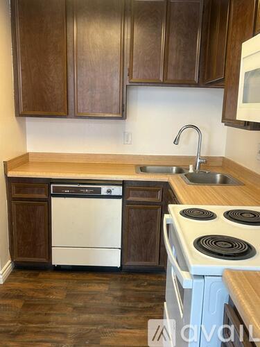 A kitchen with wooden cabinets and a white dishwasher.