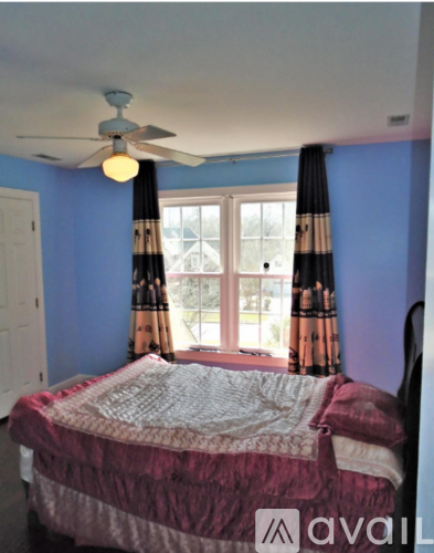 A bedroom with a bed and a ceiling fan.