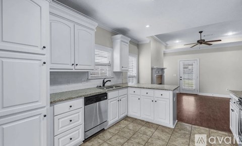 A kitchen with white cabinets and a tiled floor.