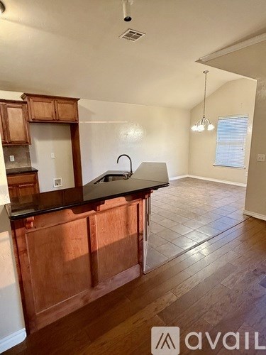 A kitchen with wooden cabinets and a black countertop.