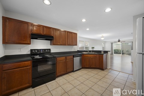 A kitchen with wooden cabinets and black countertops.