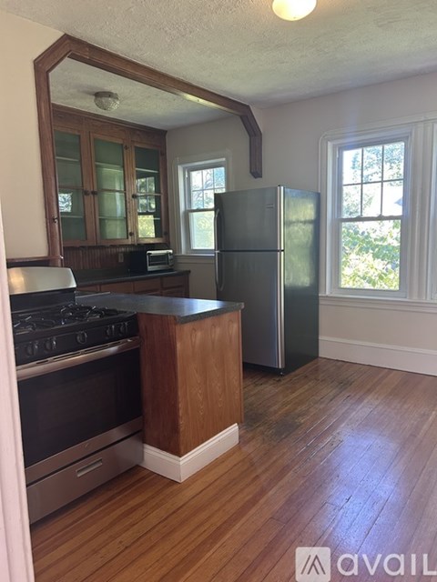 A kitchen with wooden floors and a black stove top oven.