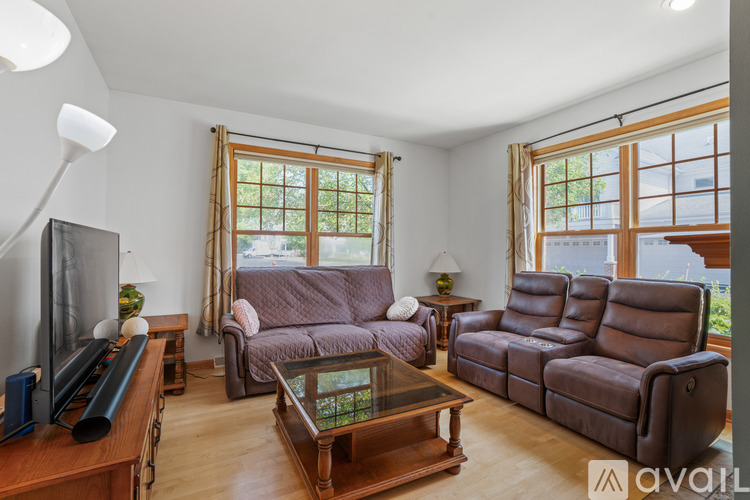 A living room with brown leather furniture and a flat screen TV.