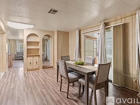 A dining room with a table and chairs.
