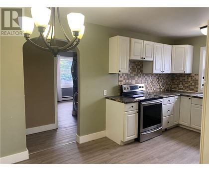 A kitchen with a stove top oven and a chandelier.