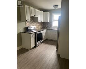 A kitchen with white cabinets and a tile backsplash.