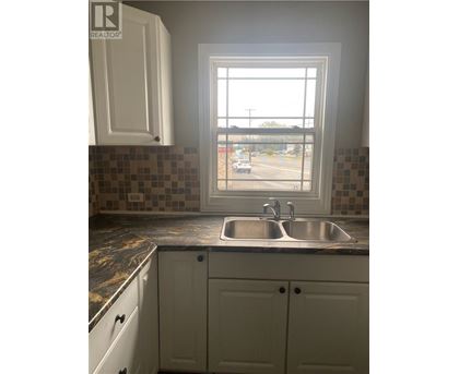 A kitchen with a sink and a window.