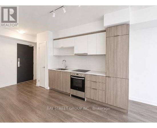 A modern kitchen with wooden cabinets and a stainless steel oven.