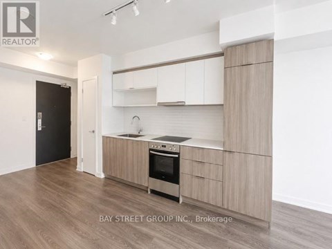 A modern kitchen with wooden cabinets and a stainless steel oven.