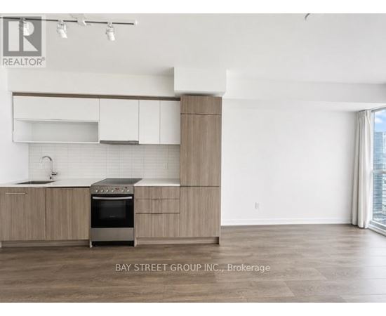 A modern kitchen with a stove top oven and a sink.