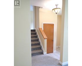 A hallway with a staircase and a door.