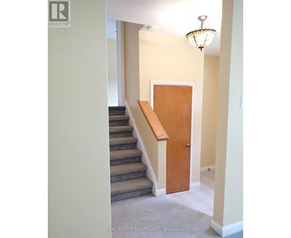 A hallway with a staircase and a door.