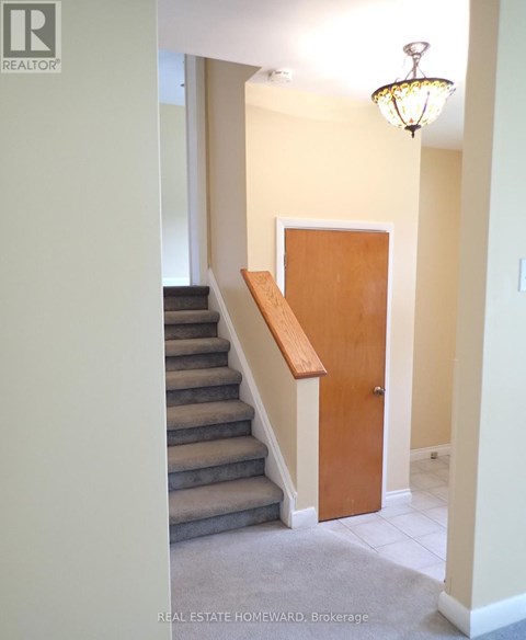 A hallway with a staircase and a door.