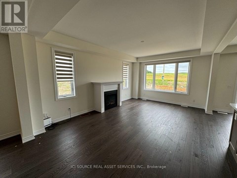 A spacious living room with hardwood floors and a fireplace.