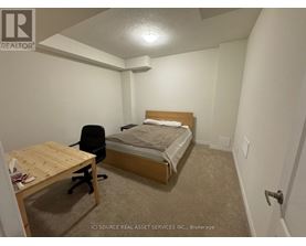 A bedroom with a bed, desk, and chair.