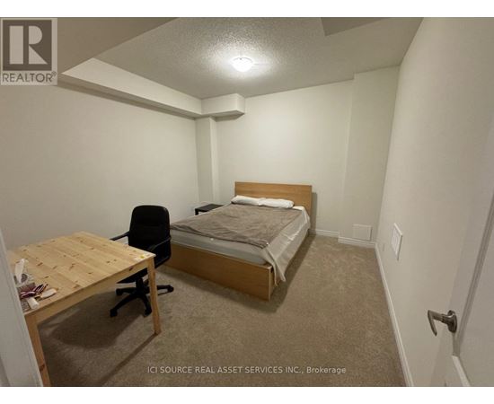 A bedroom with a bed, desk, and chair.