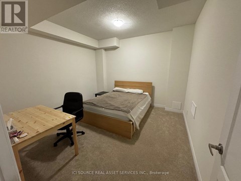 A bedroom with a bed, desk, and chair.