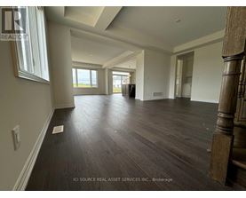 A spacious room with wooden flooring and a large window.