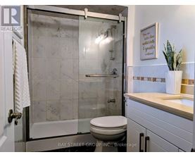 A bathroom with a toilet, a sink, and a glass shower door.