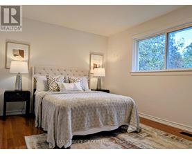 A bedroom with a large bed and two lamps.