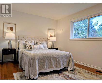 A bedroom with a large bed and two lamps.