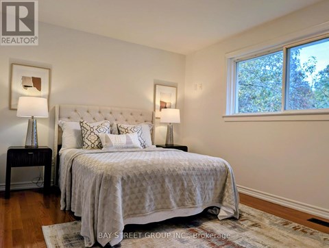 A bedroom with a large bed and two lamps.