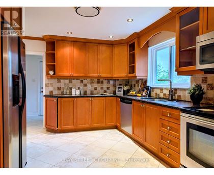 A kitchen with wooden cabinets and a black countertop.