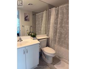 A white bathroom with a floral shower curtain.