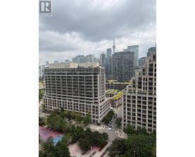 A cityscape with a large building in the foreground and a cloudy sky above.