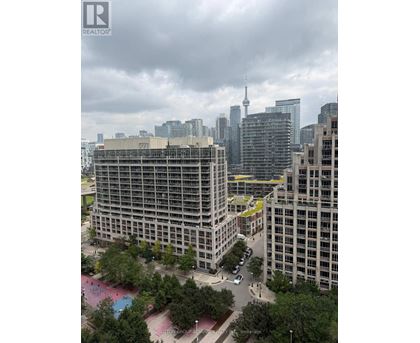 A cityscape with a large building in the foreground and a cloudy sky above.