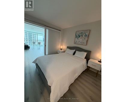 A bedroom with a large bed and a painting on the wall.