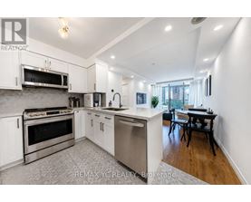 A modern kitchen with white cabinets and stainless steel appliances.