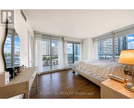 A bedroom with a large bed and a view of the city.