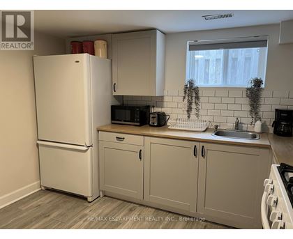 A kitchen with a white refrigerator and cabinets.