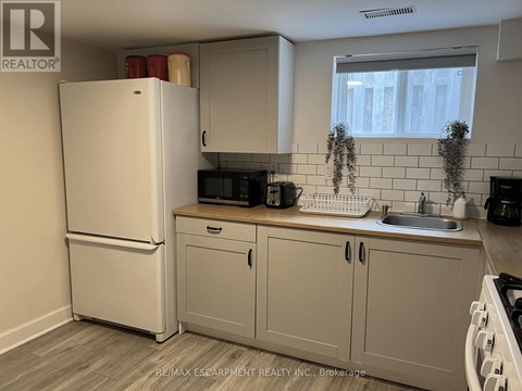 A kitchen with a white refrigerator and cabinets.