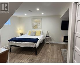 A bedroom with a bed, nightstand, and lamp.