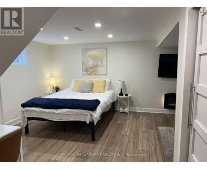 A bedroom with a bed, nightstand, and lamp.