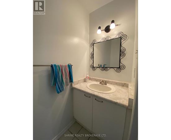 A bathroom with a sink, mirror and towel.