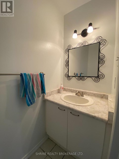 A bathroom with a sink, mirror and towel.