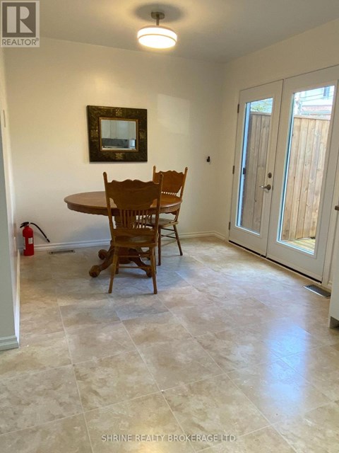 A dining room with a table and chairs.