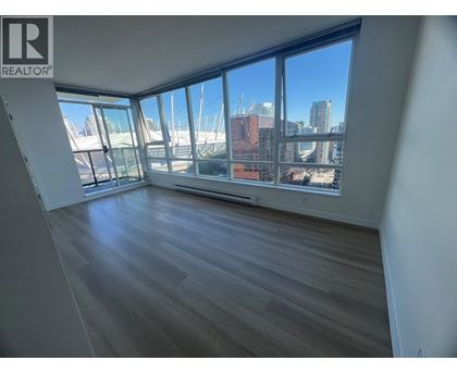 A room with wooden floors and large windows overlooking a cityscape.