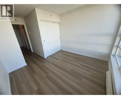 A room with wooden flooring and a white door.