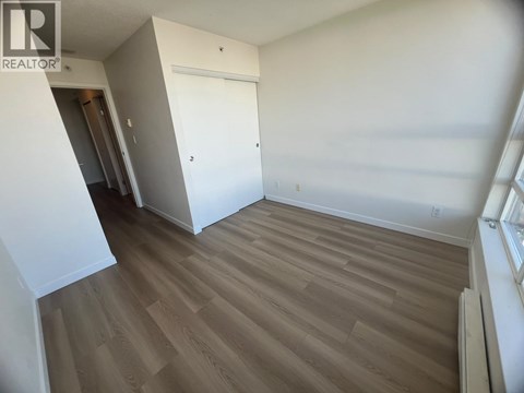 A room with wooden flooring and a white door.