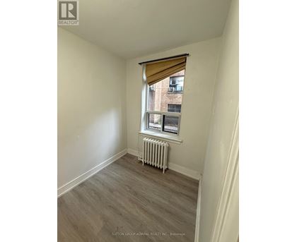 A room with a window and a radiator on the floor.