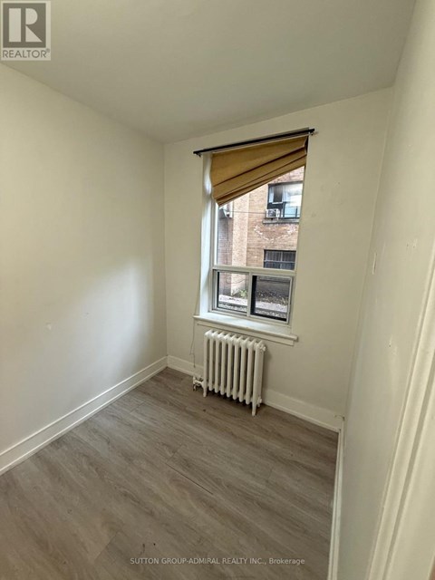 A room with a window and a radiator on the floor.