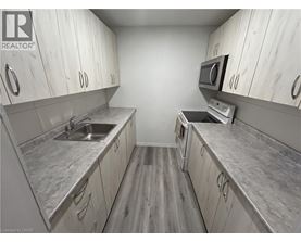 A kitchen with white cabinets and a grey counter top.