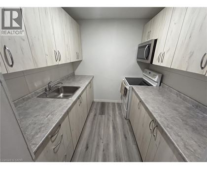 A kitchen with white cabinets and a grey counter top.