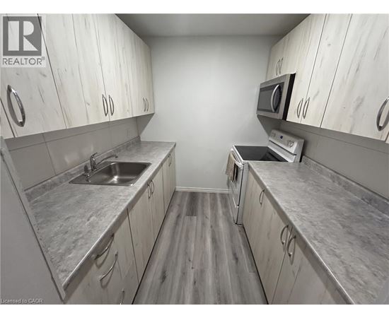 A kitchen with white cabinets and a grey counter top.