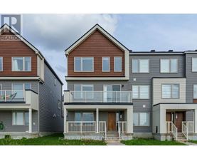 A row of townhouses with balconies and front doors.